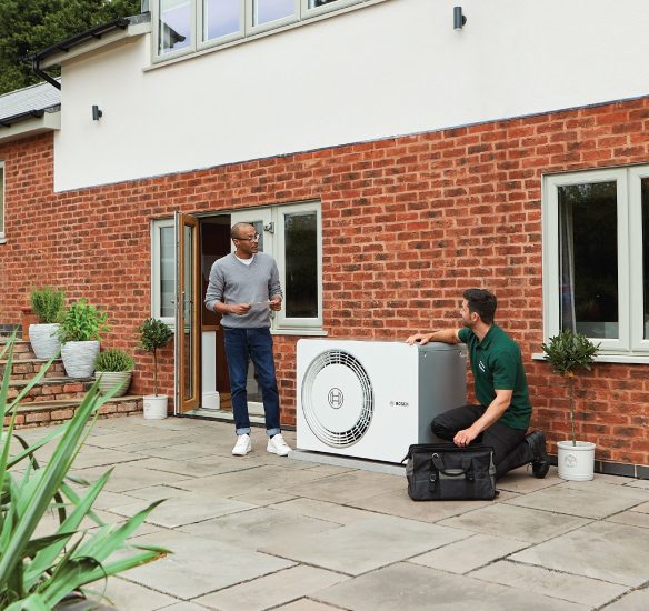 Engineer Installing Heat Pump In Garden